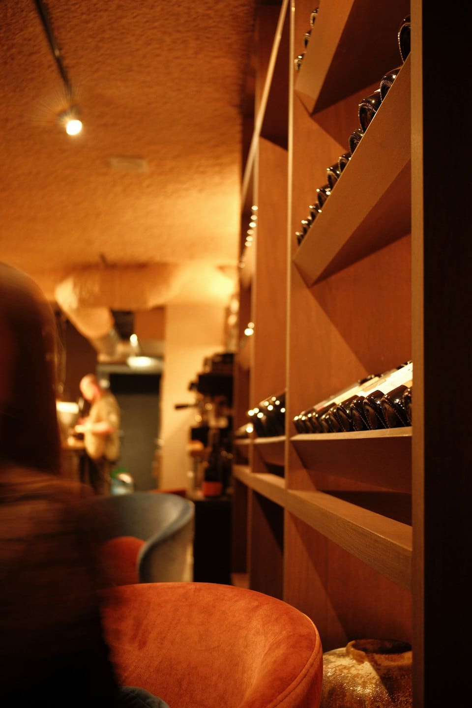 Bottiglie di vino esposte su scaffali di legno all'interno di un ristorante.